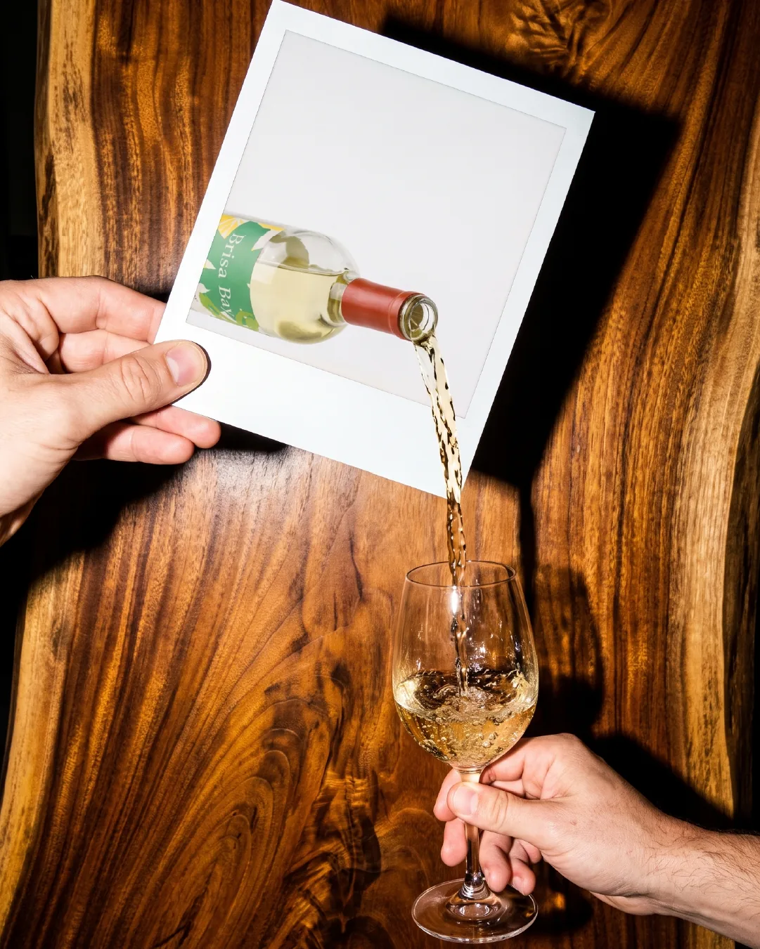 Wine pouring from a polaroid into a glass